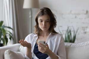 woman upset looking at an e-commerce mistake on their phone