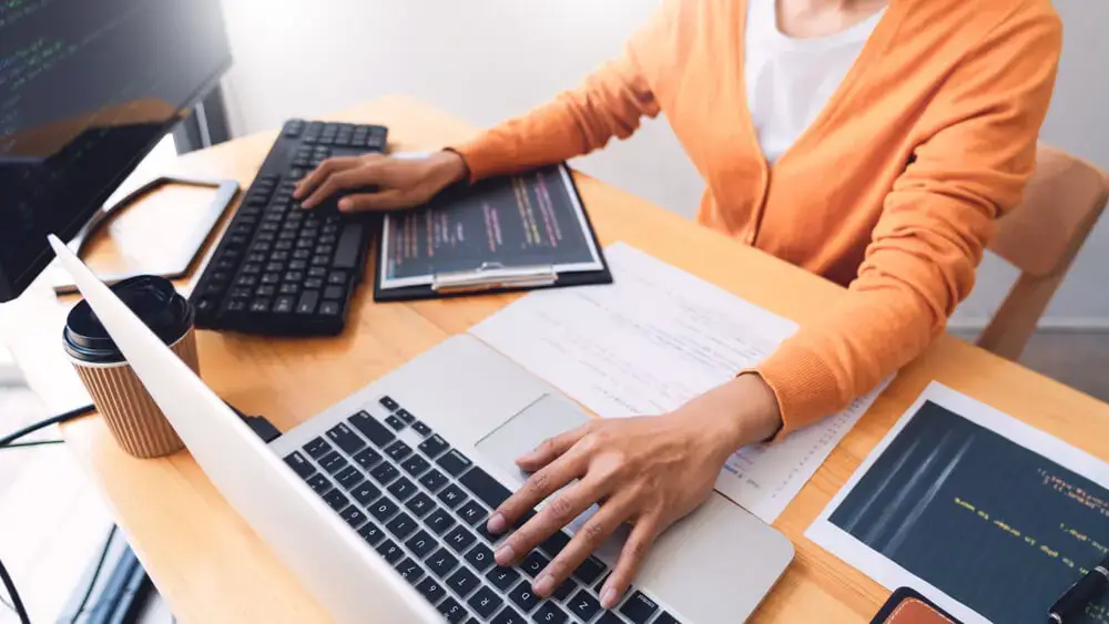 A person working on multiple computers