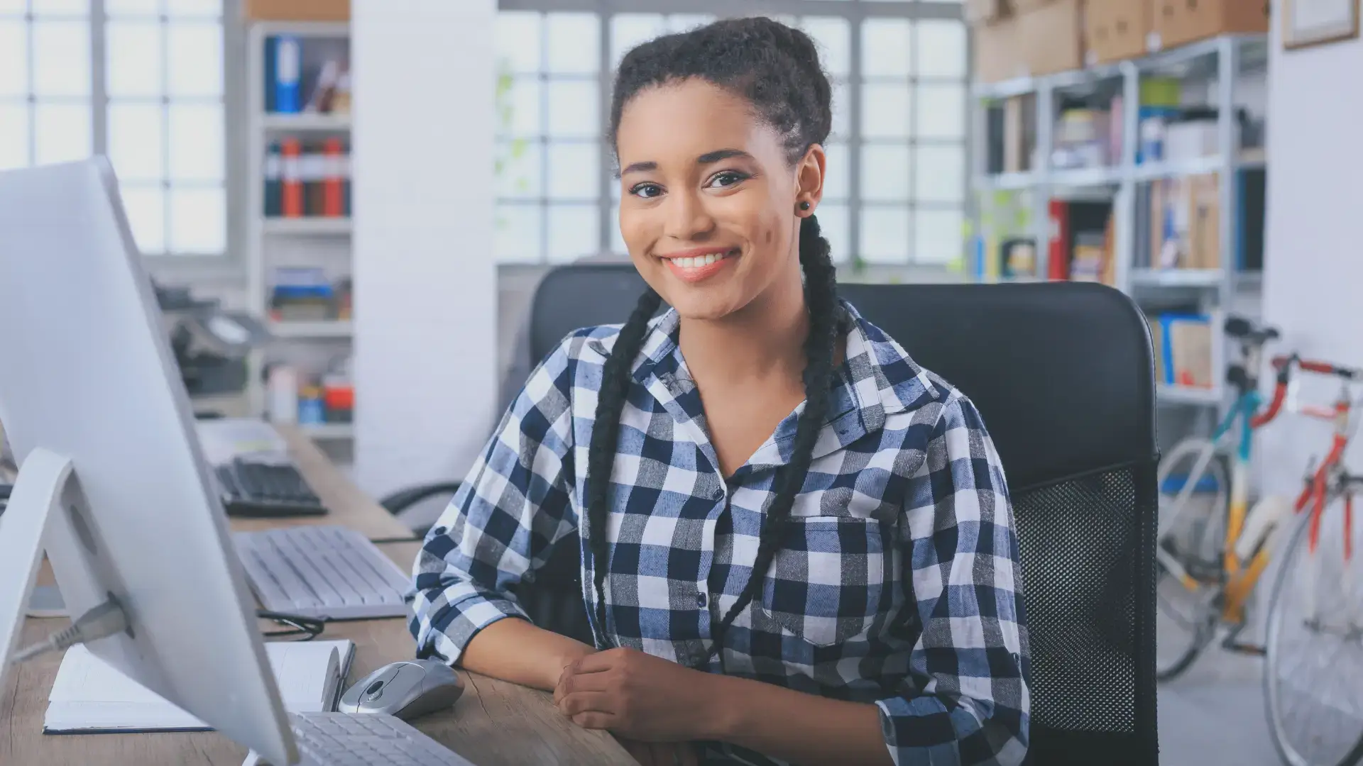 a happy woman on a desktop computer who just found and hired a great virtual assistant