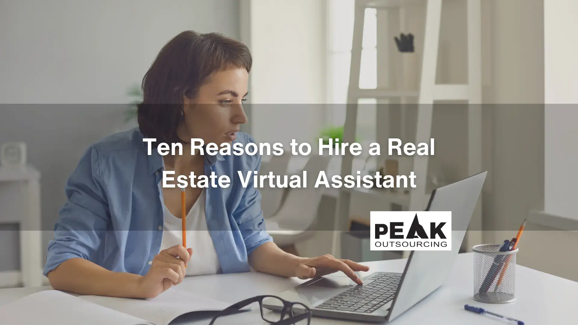 Ten Reasons to Hire a Real Estate Virtual Assistant, Woman working on a laptop while holding a pencil in a bright office
