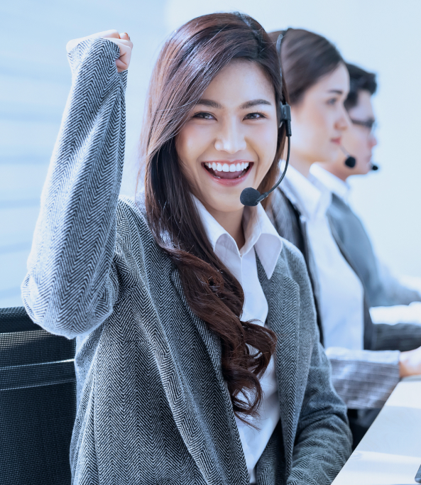 Three individuals in one frame who are working on their computers while the other one is smiling happily