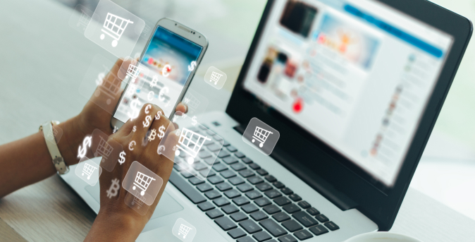 A person using a smartphone and laptop simultaneously, with digital shopping cart and dollar sign icons overlaying the image