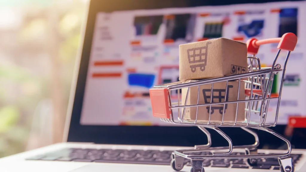 Mini shopping cart with parcels placed on a laptop, symbolizing eCommerce readiness for peak shopping seasons.