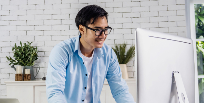 A person happily working on his computer