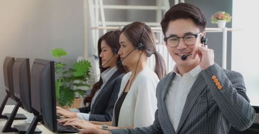Customer support team wearing headsets and working at computers.