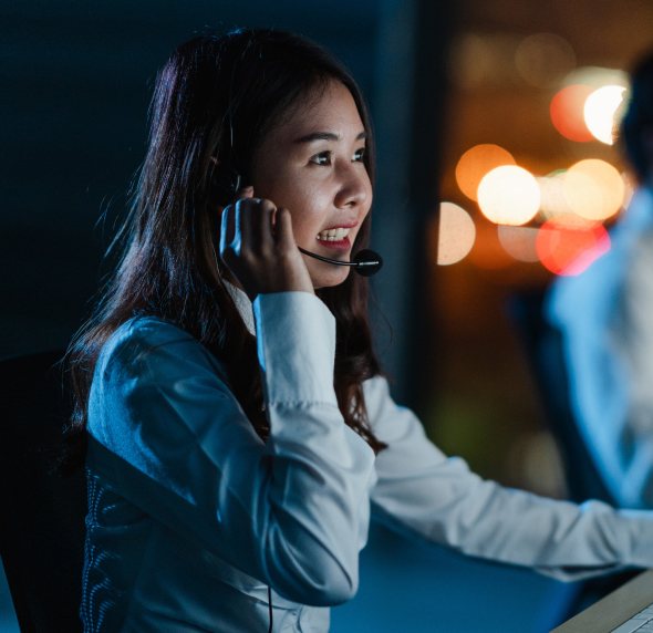 Telecom professional wearing a headset and working at night