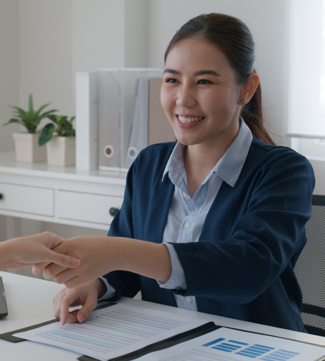 An employee shaking hands and smiling