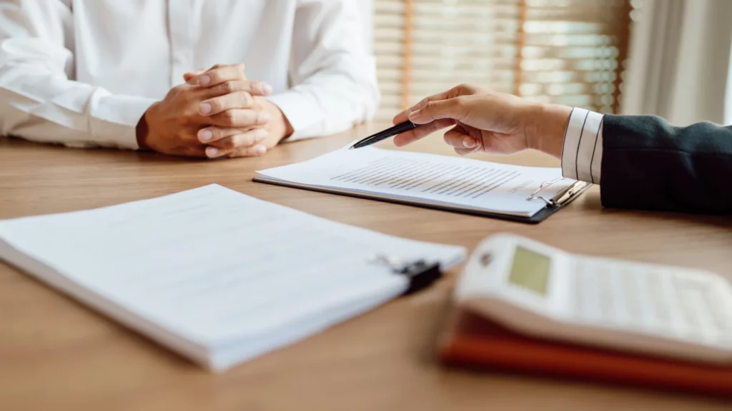 Business meeting with documents and a calculator on the table.