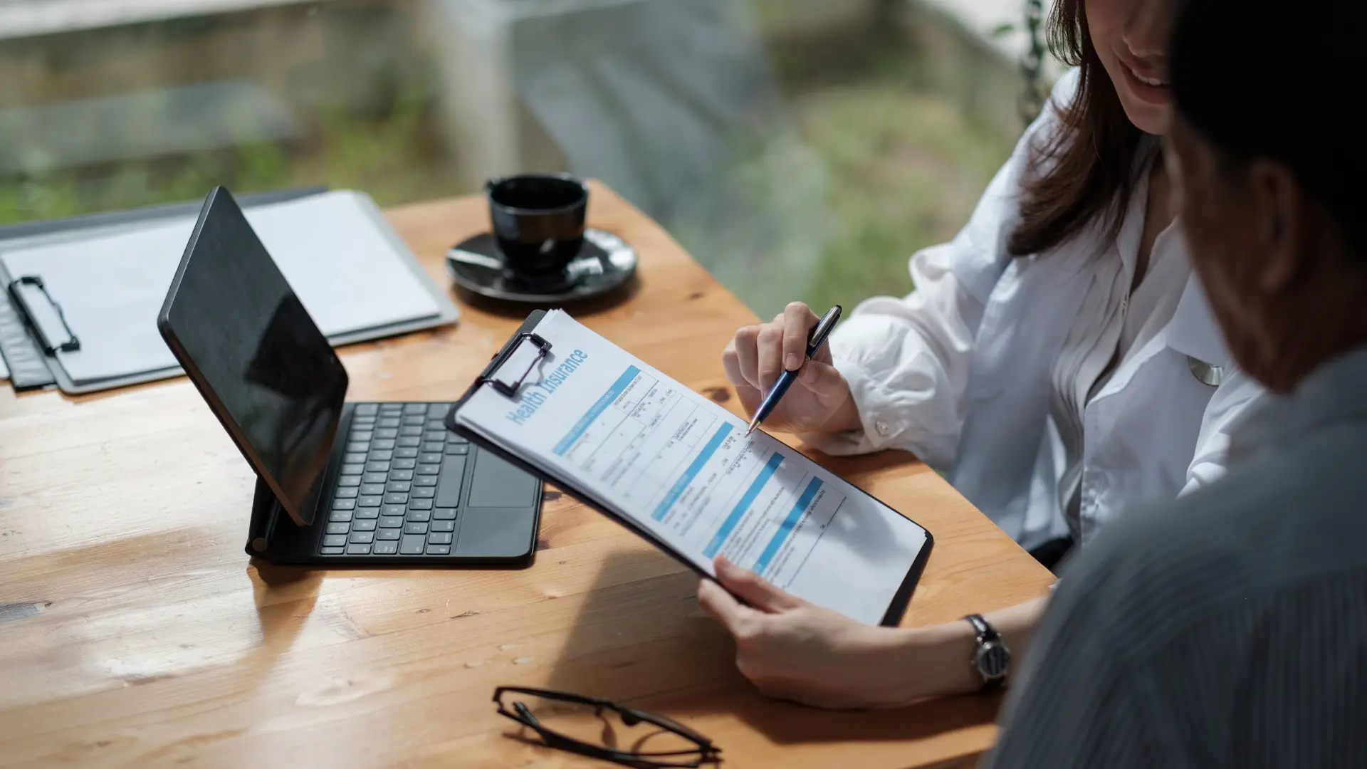Person reviewing and filling out a form on a clipboard.