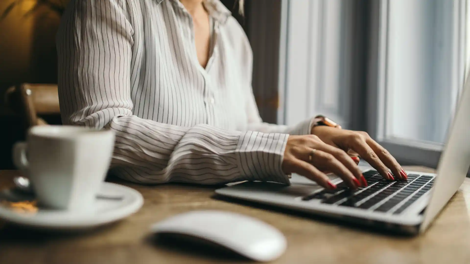 Person typing on a keyboard with a mouse nearby