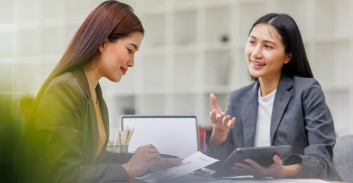 Two professionals discussing legal documents with a tablet and paperwork