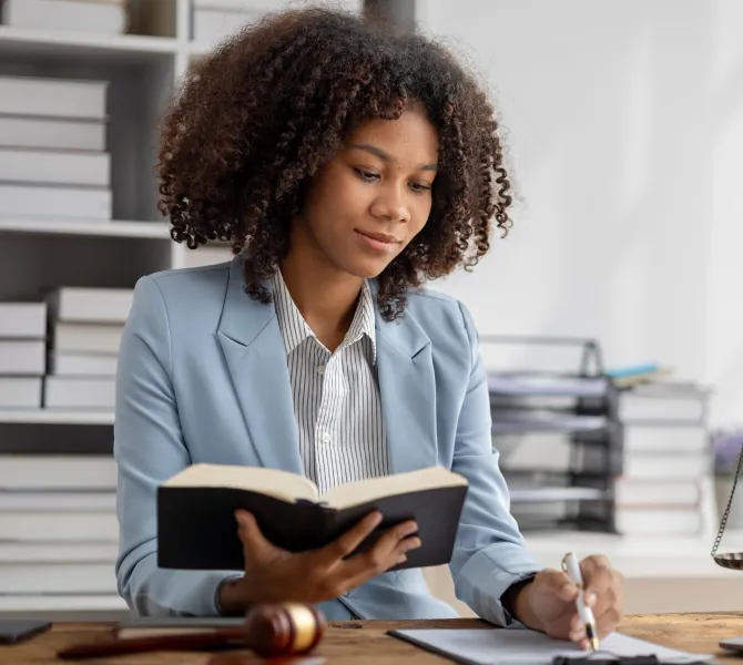 a woman reading a book while taking notes